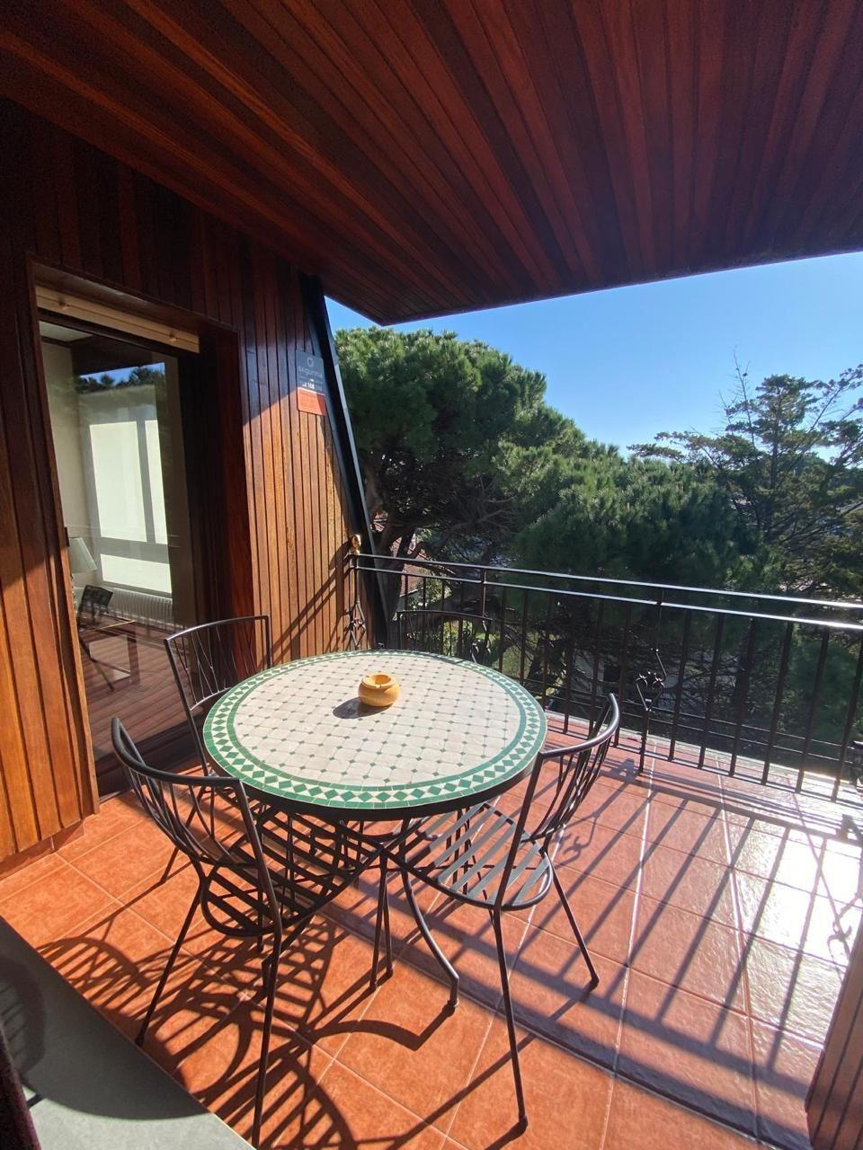 Terraza cubierta con techo de madera noble y vista a pinos
